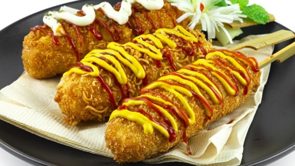 Corn dog é uma salsicha no palito com queijo mussarela, revestida com massa  de farinha e frita. comida de rua coreana de cachorro-quente